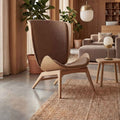 UMAGE_lifestyle_The Reader_oak_sugar brown_Paff_travertine_oak_Spring_pendant lampshade_medium_large_brass_Spring_table lamp_brass.jpeg